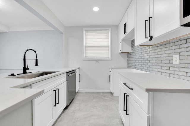 kitchen with a sink, stainless steel dishwasher, backsplash, light countertops, and white microwave
