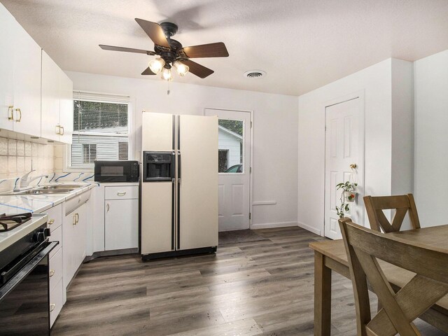 405 Jean St, Sturgis, MI 49091 - kitchen featuring white refrigerator with ice dispenser, black microwave, dark wood-type flooring, range with gas stovetop, and white cabinets