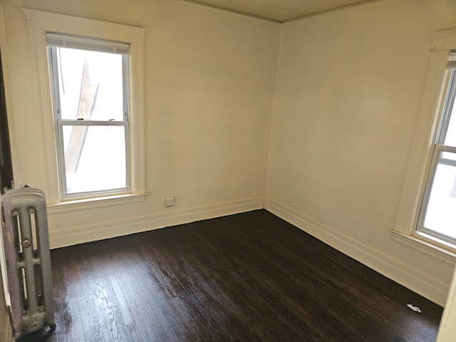 5297 Vancouver St, Detroit, MI 48204 - unfurnished room with radiator heating unit, dark wood-style flooring, plenty of natural light, and baseboards