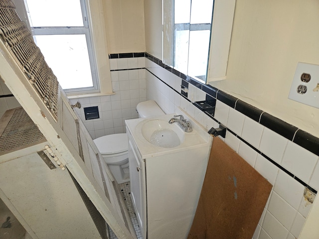 5297 Vancouver St, Detroit, MI 48204 - half bathroom featuring toilet, tile walls, vanity, and a wainscoted wall