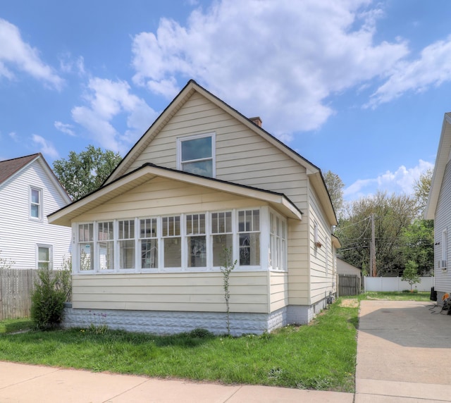 156 W 19th St, Holland, MI 49423 - view of front of house with fence, driveway, and a chimney