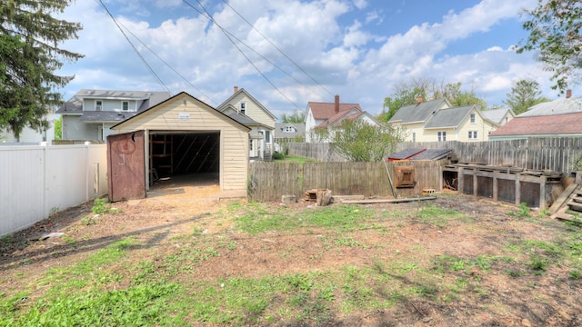 156 W 19th St, Holland, MI 49423 - fenced backyard featuring an outdoor structure, a shed, a detached garage, and a residential view