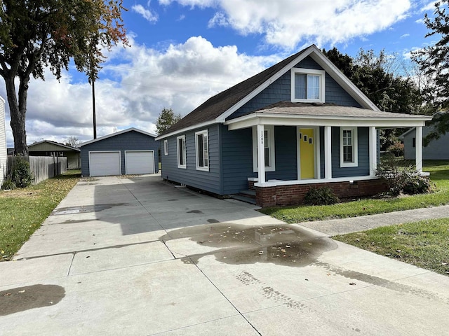 12061 Emelia St, Birch Run, MI 48415 - view of front facade with a garage, an outbuilding, covered porch, and roof with shingles