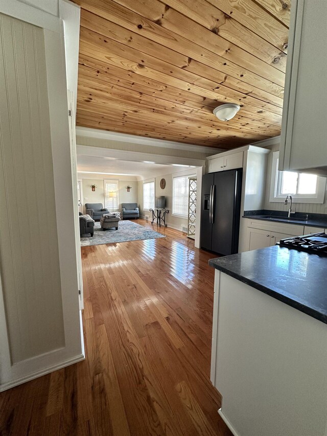 12061 Emelia St, Birch Run, MI 48415 - kitchen with fridge with ice dispenser, wood ceiling, dark countertops, white cabinets, and a sink