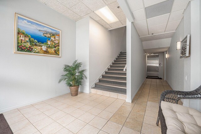 327 State St # 2, Saint Joseph, MI 49085 - stairs featuring tile patterned flooring, a paneled ceiling, and baseboards