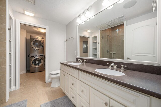 327 State St # 2, Saint Joseph, MI 49085 - full bath with stacked washer and clothes dryer, tile patterned flooring, a stall shower, double vanity, and toilet