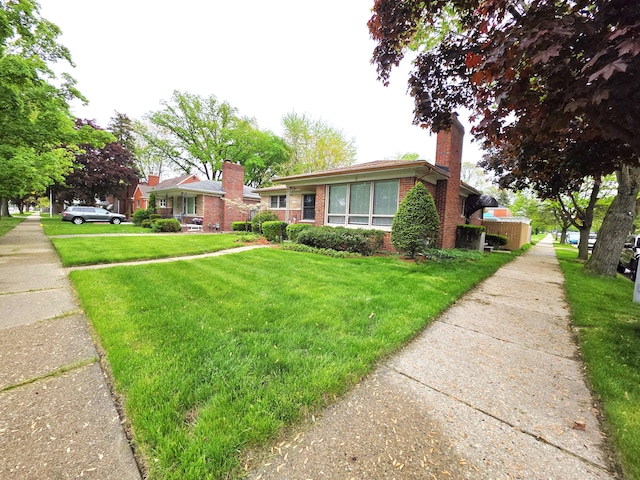 19266 Tyrone St, Harper Woods, MI 48225 - view of front of house featuring brick siding, a front yard, and a chimney