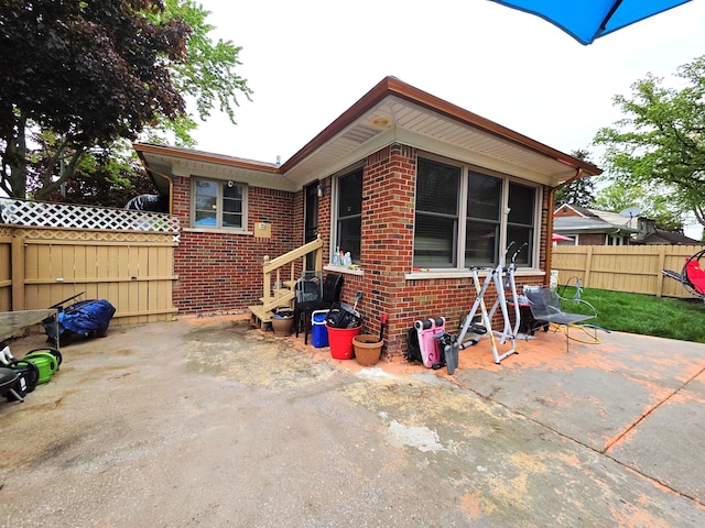 19266 Tyrone St, Harper Woods, MI 48225 - back of house with brick siding, fence, a patio, and entry steps