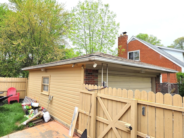 19266 Tyrone St, Harper Woods, MI 48225 - view of home's exterior featuring fence, a chimney, brick siding, a gate, and an attached garage