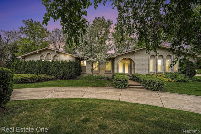 3079 Ravinewood Dr, Commerce Twp, MI 48382 - view of front of home with a front lawn and brick siding