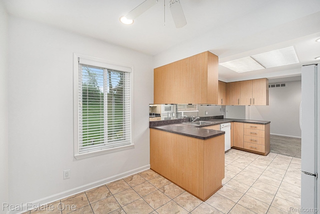 3079 Ravinewood Dr, Commerce Twp, MI 48382 - kitchen featuring a peninsula, a sink, white appliances, dark countertops, and baseboards