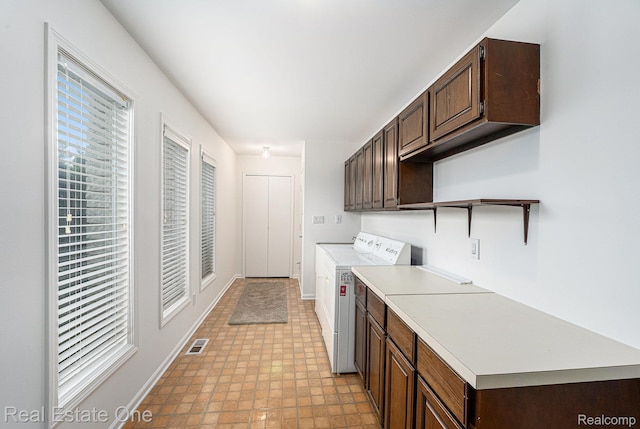 3079 Ravinewood Dr, Commerce Twp, MI 48382 - washroom featuring cabinet space, washer and clothes dryer, baseboards, and light flooring