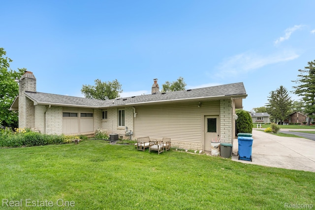 3079 Ravinewood Dr, Commerce Twp, MI 48382 - back of house featuring a chimney, a lawn, central air condition unit, and a shingled roof