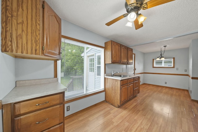 5732 Selfridge Blvd, Lansing, MI 48911 - kitchen with a textured ceiling, brown cabinetry, light wood finished floors, and light countertops