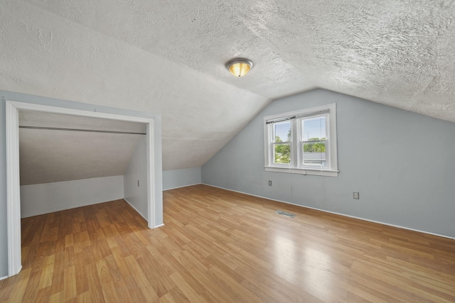 5732 Selfridge Blvd, Lansing, MI 48911 - additional living space with wood finished floors, vaulted ceiling, and a textured ceiling