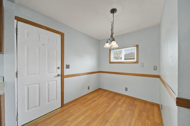 5732 Selfridge Blvd, Lansing, MI 48911 - unfurnished dining area featuring light wood finished floors, a chandelier, and a textured ceiling