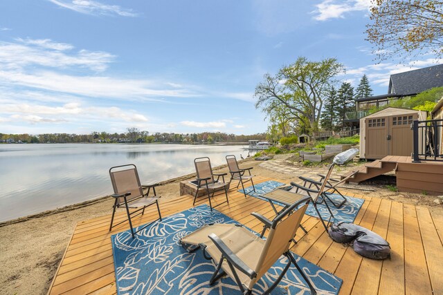 9417 Cedar Island Rd, White Lake, MI 48386 - wooden deck featuring a storage shed, a water view, and an outdoor structure
