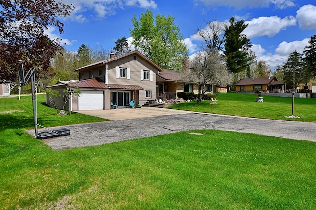 9609 E Madison Rd, Saint Helen, MI 48656 - view of front of home with a chimney, concrete driveway, a standing seam roof, metal roof, and a front lawn