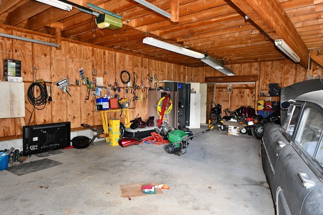 9609 E Madison Rd, Saint Helen, MI 48656 - garage with a garage door opener and wooden walls