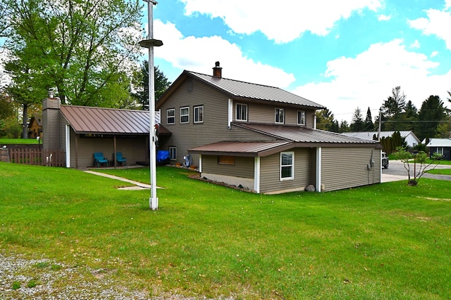 9609 E Madison Rd, Saint Helen, MI 48656 - rear view of house featuring a chimney, metal roof, and a lawn