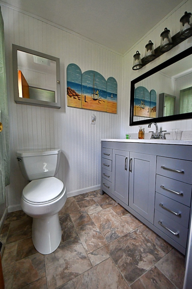 9609 E Madison Rd, Saint Helen, MI 48656 - full bathroom with baseboards, stone tile flooring, vanity, toilet, and wood walls