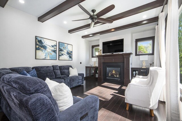 living room featuring beamed ceiling, a glass covered fireplace, wood finished floors, ceiling fan, and recessed lighting