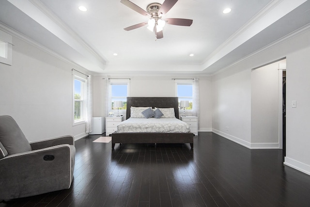 bedroom featuring a raised ceiling, dark wood finished floors, a ceiling fan, baseboards, and crown molding