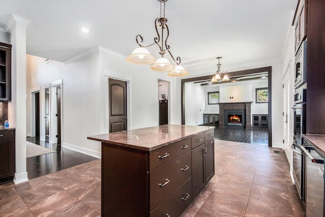 8030 Lionel Dr SW, Byron Center, MI 49315 - kitchen featuring crown molding, a kitchen island, dark brown cabinets, a lit fireplace, and stainless steel oven