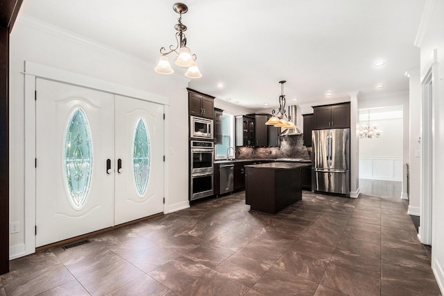 8030 Lionel Dr SW, Byron Center, MI 49315 - kitchen with appliances with stainless steel finishes, a chandelier, crown molding, decorative backsplash, and a center island