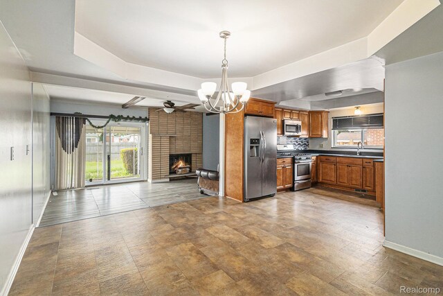 11414 Nancy Dr, Warren, MI 48093 - kitchen featuring stainless steel appliances, brown cabinetry, open floor plan, a chandelier, and dark countertops