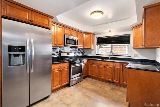 11414 Nancy Dr, Warren, MI 48093 - kitchen with appliances with stainless steel finishes, brown cabinets, a raised ceiling, and dark countertops