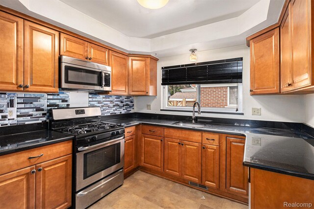 11414 Nancy Dr, Warren, MI 48093 - kitchen with appliances with stainless steel finishes, a sink, brown cabinetry, and decorative backsplash