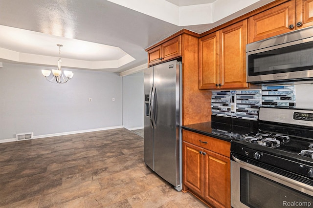 11414 Nancy Dr, Warren, MI 48093 - kitchen with appliances with stainless steel finishes, brown cabinetry, a chandelier, a raised ceiling, and pendant lighting