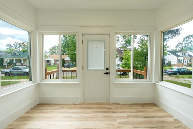 unfurnished sunroom featuring plenty of natural light and wood finished floors