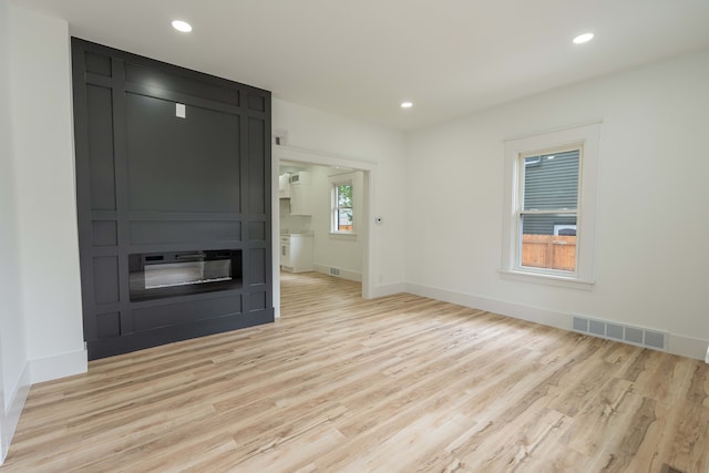 unfurnished living room featuring light wood-style floors, baseboards, and recessed lighting