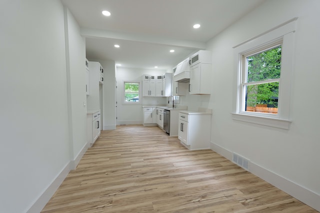 kitchen featuring custom range hood, glass insert cabinets, stainless steel dishwasher, recessed lighting, and light wood finished floors