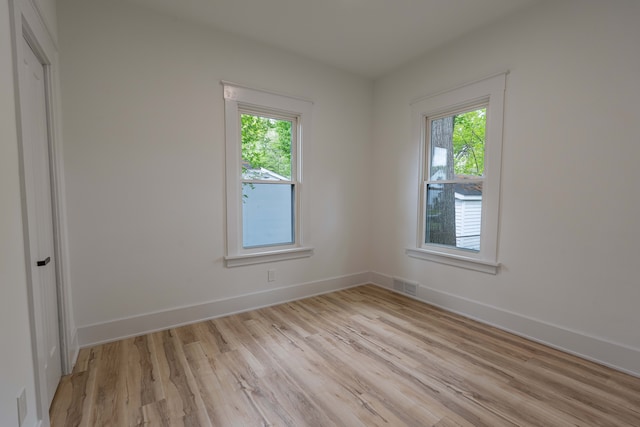 empty room with light wood-style flooring and baseboards