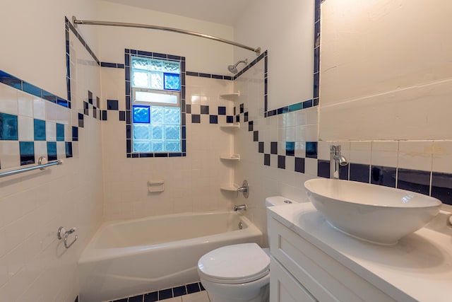 bathroom featuring tile walls, shower / washtub combination, toilet, and vanity