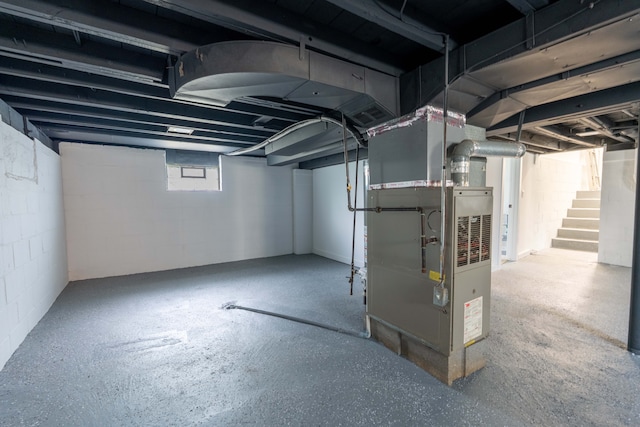 basement with heating unit and stairway