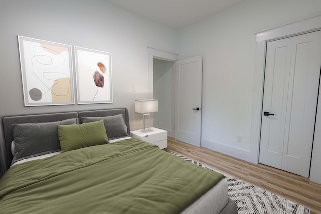 bedroom with light wood-style floors and a closet