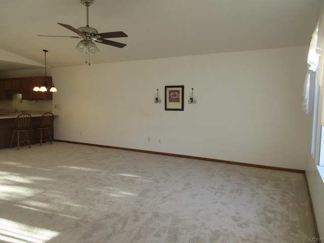 1303 Carriage Dr, Tecumseh, MI 49286 - unfurnished living room with vaulted ceiling, light carpet, a chandelier, ceiling fan, and baseboards