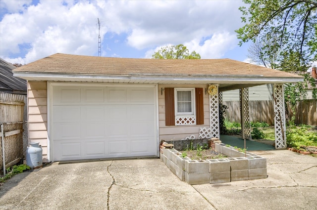 view of front of home featuring driveway, fence, and a garage