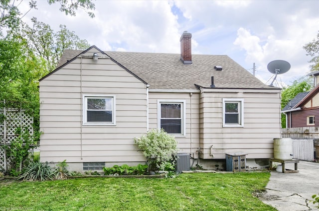 back of property featuring a shingled roof, a chimney, and central air condition unit