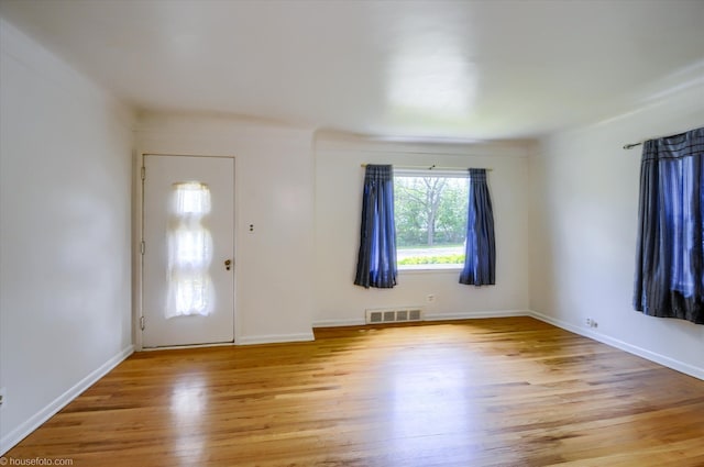 foyer entrance with light wood-style flooring and baseboards