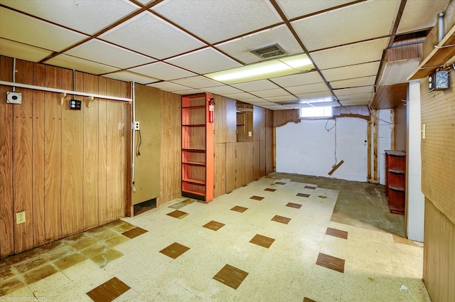 below grade area featuring wooden walls and tile patterned floors
