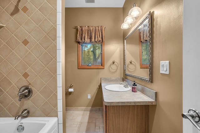 186 Goldsmith Dr, Clarklake, MI 49234 - full bathroom featuring vanity, baseboards, tub / shower combination, and stone tile floors