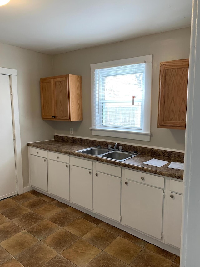 954 Adams St SE, Grand Rapids, MI 49507 - kitchen with a sink, dark countertops, and dark stone finish flooring