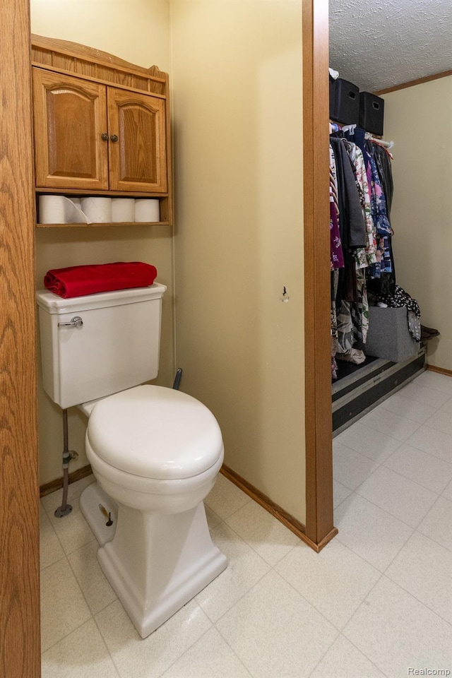 4232 Washburn Rd, Vassar, MI 48768 - bathroom with toilet, baseboards, and a textured ceiling