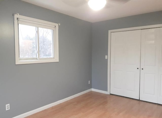 2205 Regina Ave, Lincoln Park, MI 48146 - unfurnished bedroom featuring light wood-style floors, a closet, baseboards, and ceiling fan