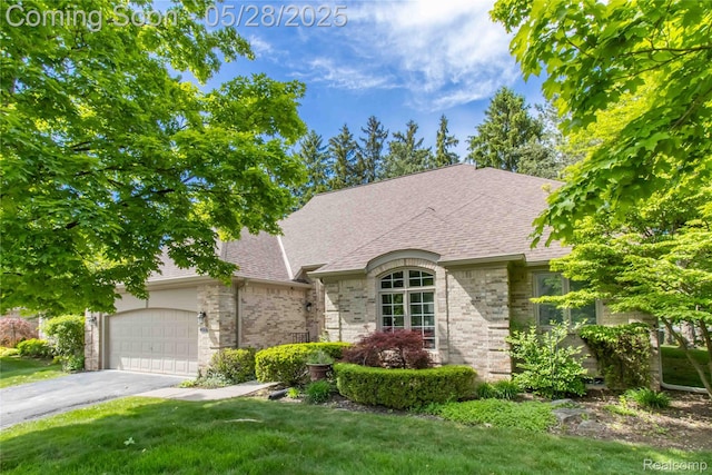 22170 Orchard Way, Beverly Hills, MI 48025 - french country home with an attached garage, asphalt driveway, a shingled roof, a front yard, and brick siding